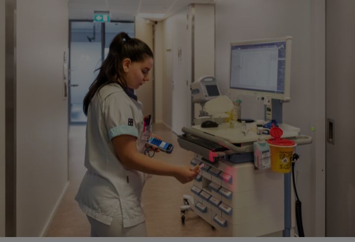 Nurse scanning equipment in hospital hallway